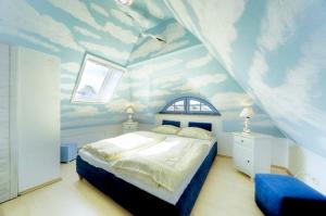 ツィングストにあるAntjes Deichblickのベッドルーム1室(天井に雲が描かれたベッド1台付)