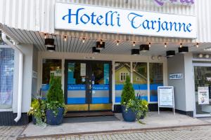 a hotel entrance with potted plants in front of it at Huoneistohotelli Tarjanne Virrat in Virrat