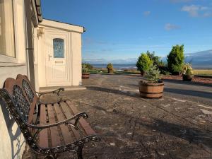 a wooden bench sitting outside of a building at Solway Firth View in Annan