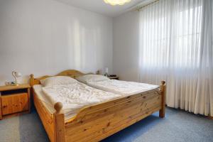 a bedroom with a wooden bed and a window at Waldesruh - FW in Zingst