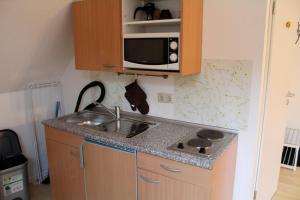 a small kitchen with a sink and a microwave at Haus Wagner App 2 in Heiligenhafen