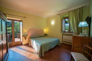 a bedroom with a bed in a room with windows at Cavarchino B&B in Gaiole in Chianti