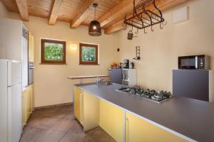 a large kitchen with a counter top and a refrigerator at Villa Cipressi - Luxuri Lounge - in Malcesine