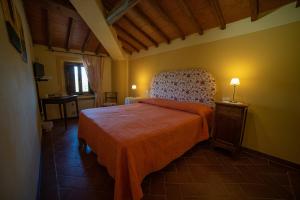 a bedroom with a bed and a chair in a room at Cavarchino B&B in Gaiole in Chianti