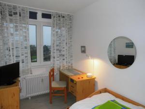 ハイリゲンハーフェンにあるLübker, FP L-3-8のベッドルーム(デスク、ベッド、鏡付)