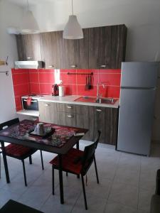 uma cozinha com uma mesa e um frigorífico branco em City Apartment em Lerápetra