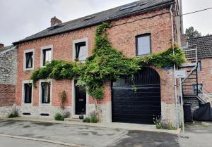 an old brick building with a black garage at Charmante duplex in Andenne
