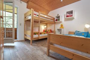 a bedroom with two bunk beds and a wooden ceiling at Ferienhof Wuchner - Fewo "Sommerwiese" in Fröhnd