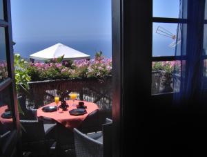 einen Tisch mit einem roten Tischtuch auf dem Balkon in der Unterkunft Apartment mit privatem Balkon sowie Meer- und Gebirgsblick im modernen Stil in Icod de los Vinos