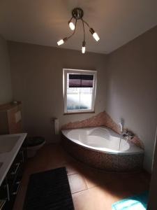 a large bath tub in a bathroom with a window at Reiterhof vom Litzlbach in Langquaid