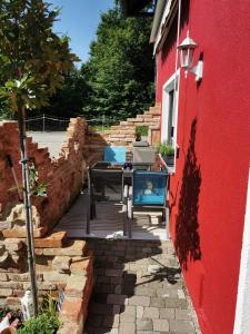 un patio con una mesa y un edificio rojo en Reiterhof vom Litzlbach, en Langquaid