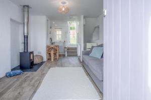 uma sala de estar com um sofá e uma lareira em Brook Cottage - 1 Bedroom Cottage - Dale em Dale