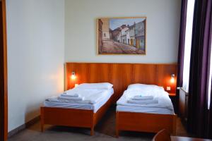 Un pat sau paturi într-o cameră la Hotel Praha Liberec