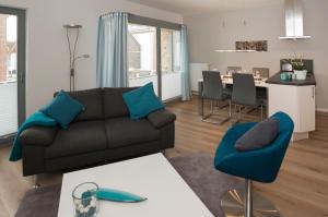 ハイリゲンハーフェンにあるOstsee - Appartement Nr 87a "Strandkorb" im Strand Resortのリビングルーム(ソファ、テーブル付)