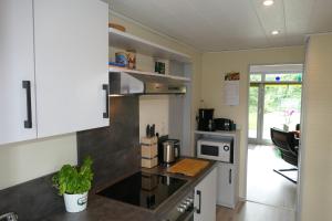 a kitchen with white cabinets and a counter top at Frietied am Wittensee in Bünsdorf