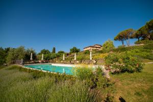 a swimming pool in a field with a house in the background at Cavarchino B&B in Gaiole in Chianti