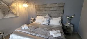 a bedroom with a bed with two white towels on it at Rox and Sea Country Lodge in Langebaan