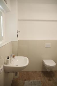 a white bathroom with a sink and a toilet at Casa Kronengarten Nr 6 in Hilden