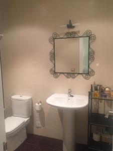 uma casa de banho com um lavatório, um WC e um espelho. em Apartamento Balcón de Jaca em Jaca