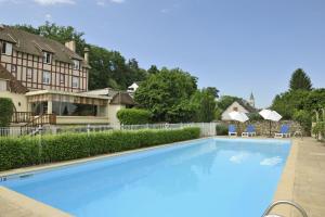 a large blue swimming pool in front of a house at Hostellerie Du Chateau in Chaumont-sur-Loire