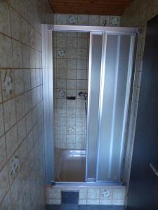 y baño con ducha, bañera y azulejos. en Ferienhaus Rombach Wohnung A en Wieden