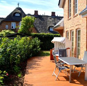 un patio con mesa y sillas en una terraza en Dreamhus Borgsum en Borgsum