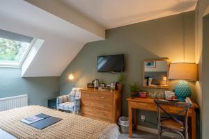 een slaapkamer met een bed, een bureau en een televisie bij The Bird In Hand in Maidenhead