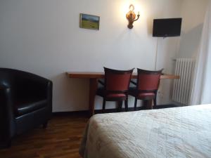 a hotel room with a table and chairs and a bed at Hôtel Soleil des Neiges in Le Sauze