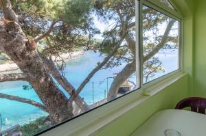 a window with a view of the beach and water at Guesthouse Karbuni (217) in Blato