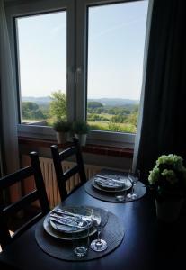 una mesa con platos y vasos con vistas en Ruhige Ferienwohnung mit Fernblick en Modautal