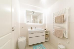 a white bathroom with a sink and a toilet at Whg 02 - MeerFreude in Zingst