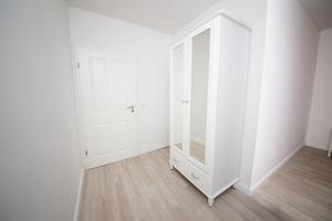 Habitación vacía con espejo y paredes blancas en Schleiblick App 9, en Rabenkirchen-Faulück