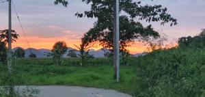 a pole in a field with a sunset in the background at Superior House Khaoyai in Ban Khanong Phra Klang (1)