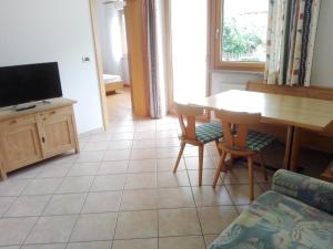 ein Wohnzimmer mit einem Tisch und einem TV in der Unterkunft Ferienwohung im Haus Texel I in Rabland