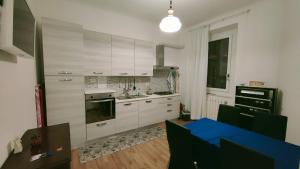 a kitchen with white cabinets and a blue table at Amedeo in Civitanova Marche