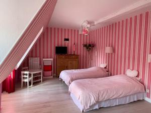 um quarto com 2 camas e uma escada com riscas cor-de-rosa em La Métairie em Vernou-sur-Brenne