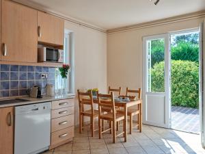 a kitchen with a table and chairs and a kitchen with a window at Fövenyes House Grande in Balatonudvari