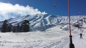 une personne est en train de skier sur une montagne enneigée dans l'établissement Etna Sunshine Piedimonte, à Piedimonte Etneo