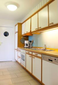 eine Küche mit Holzschränken und weißen Geräten in der Unterkunft Seepark - Oberdeck in Grömitz
