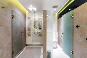 a bathroom with a shower and a toilet at Cross Chiang Mai Riverside in Chiang Mai