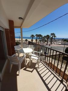 a balcony with a table and chairs and the beach at Apartamentos Dins Mar Apto. 6 in Torredembarra