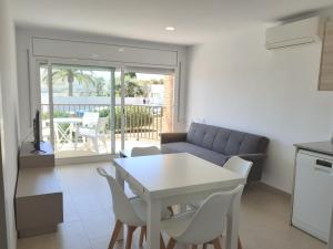 a living room with a couch and a table and chairs at Apartamentos Dins Mar Apto. 6 in Torredembarra +12 photos