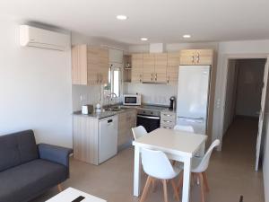 a small kitchen with a white table and a couch at Apartamentos Dins Mar Apto. 6 in Torredembarra