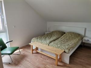 a bedroom with a bed and a table and a chair at Sonnenufer Apartment & Moselwein I in Bernkastel-Kues