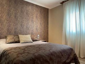 um quarto com uma cama grande e uma janela em La Siesta em Villamarciel