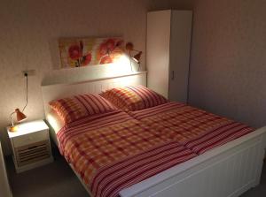 a bedroom with a bed with a striped comforter at "Uns Schün" Nr 2 in Fehmarn