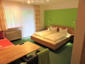 Dormitorio verde con cama y mesa en Ferienhaus Weiß, Sandra Weiß en Füssen