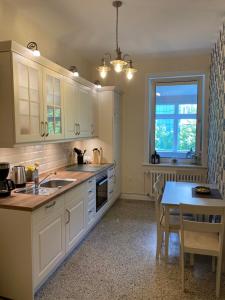a kitchen with white cabinets and a table and a window at Schöne Ferienwohnung in der City Königswohnung Jun in Kiel