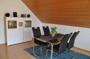 a dining room with a table and black chairs at Haus Franke in Langenargen