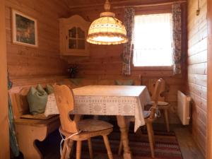 comedor en una cabaña de madera con mesa y sillas en Ferienhaus Nr 24, Typ A, Feriendorf Jägerpark, Bayerischer Wald, en Viechtach